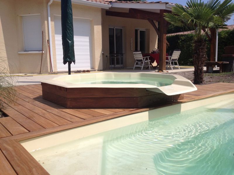 Aménagement autour d'une piscine avec un bassin cascade