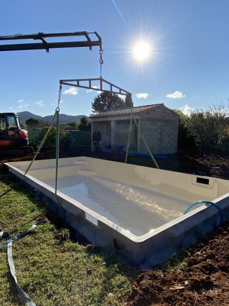 Calage d'une piscine coque dans un trou après terrassement
