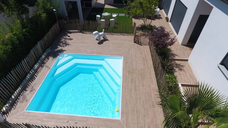 Piscine carré 4x4 m terrasse carrelage imitation bois